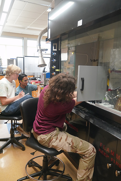 Stevens High School students Shourya Goyal, Dylan Tipton, a lab volunteer, and Emma Kinyon research the effectiveness of granular activated carbon in removing harmful chemicals.