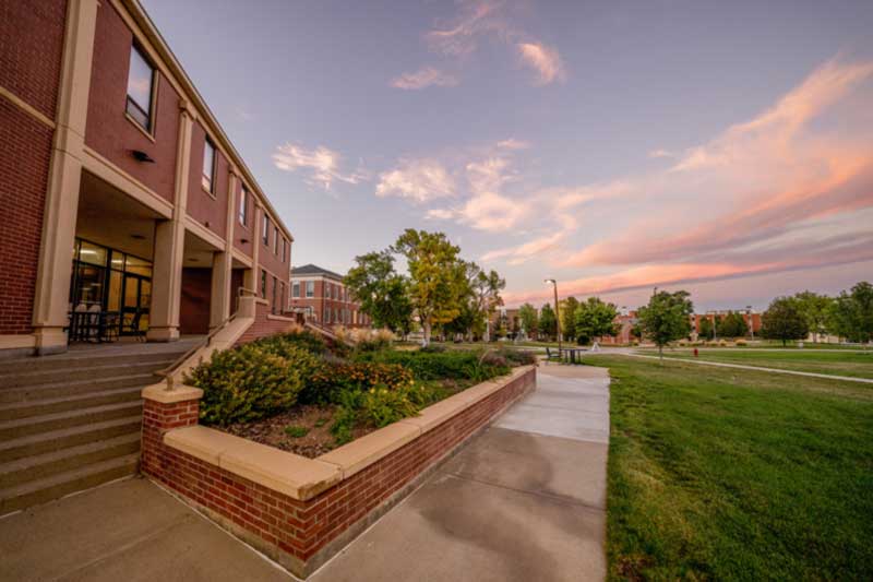 University campus building with walkway and green lawn.