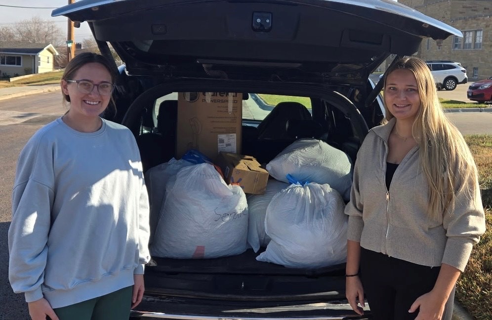 Alpha Delta Pi sorority members Samantha Winker, junior mechanical engineering major, and Alayna Dressler, senior industrial engineering major, drop off the 212 pounds of pop tabs to Rob Bradford, mission director for Ronald McDonald House South Dakota.